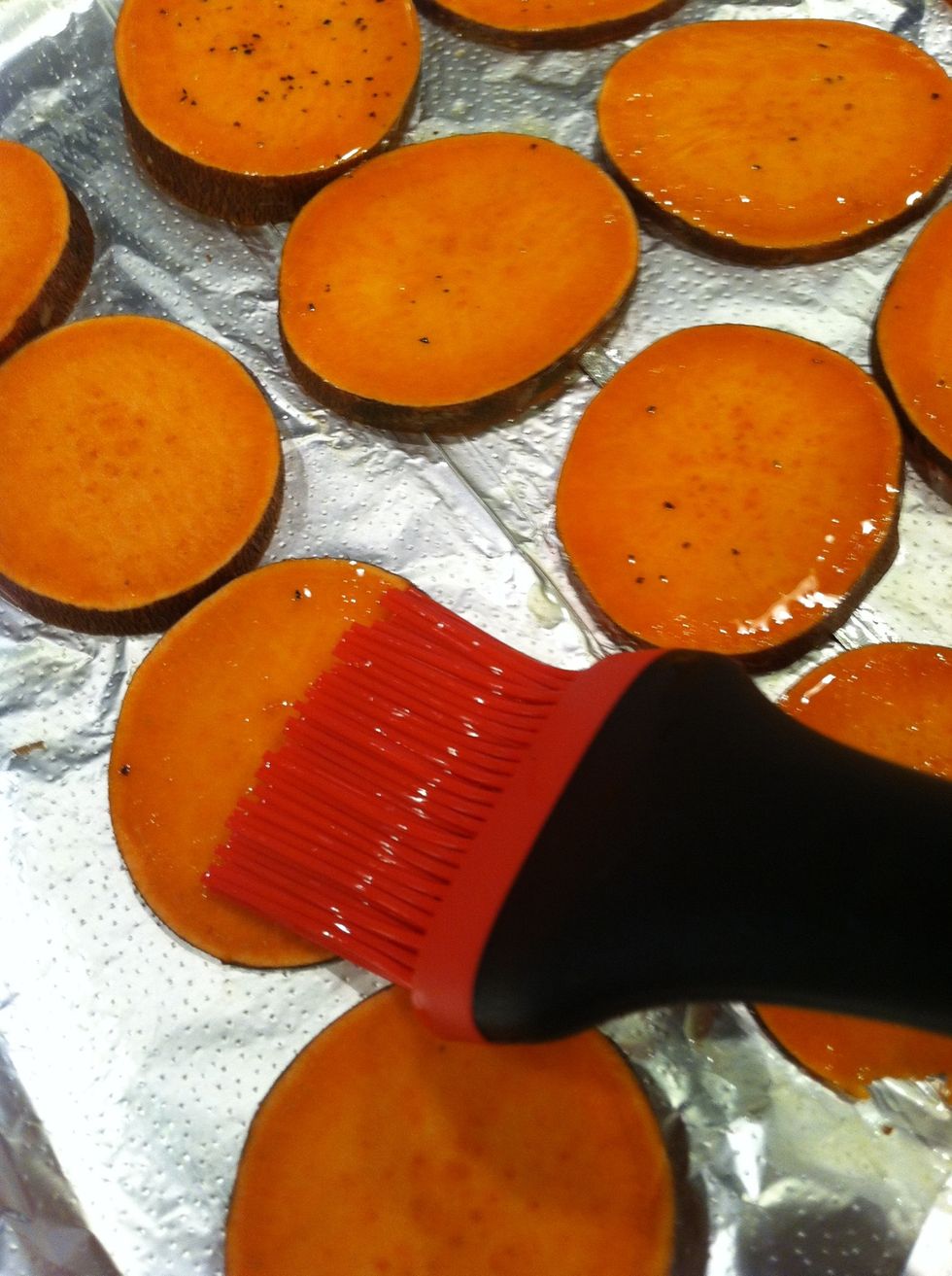 Dip your brush into the oil/butter again, and brush your sweet potato slices liberally. Only use about half of the oil; you'll need the rest later on.