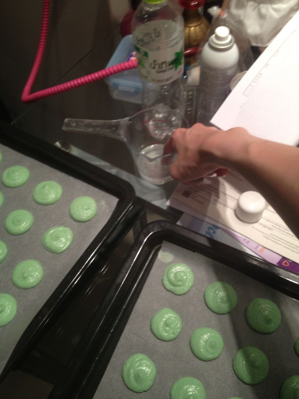 Dip your finger in water and touch the pointy bit to perfect the macarons.