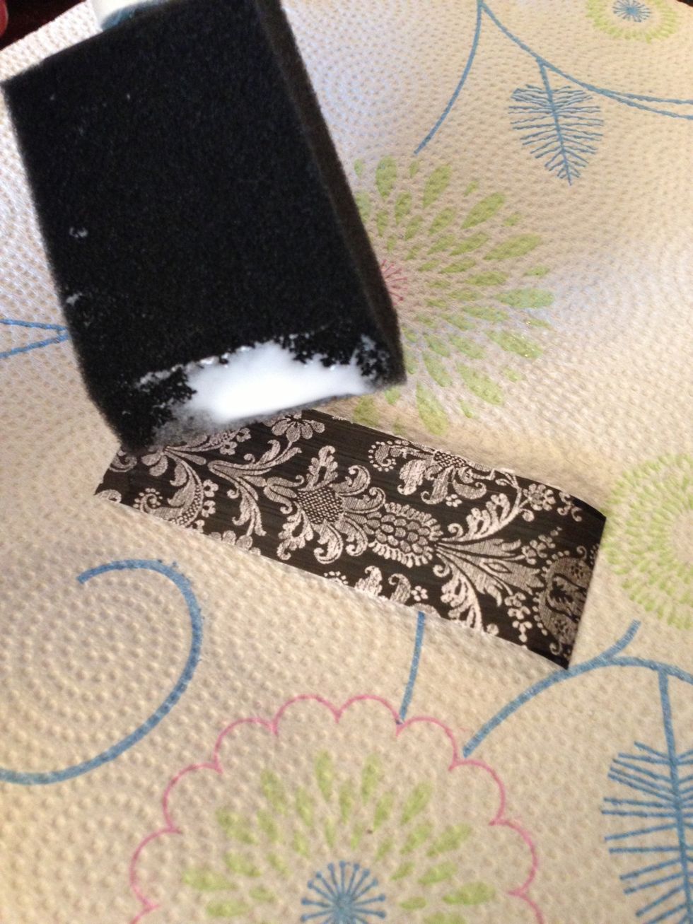 Dip your sponge brush in the glue and paint the glue along the patterned side of the paper strip. NOT the white side!