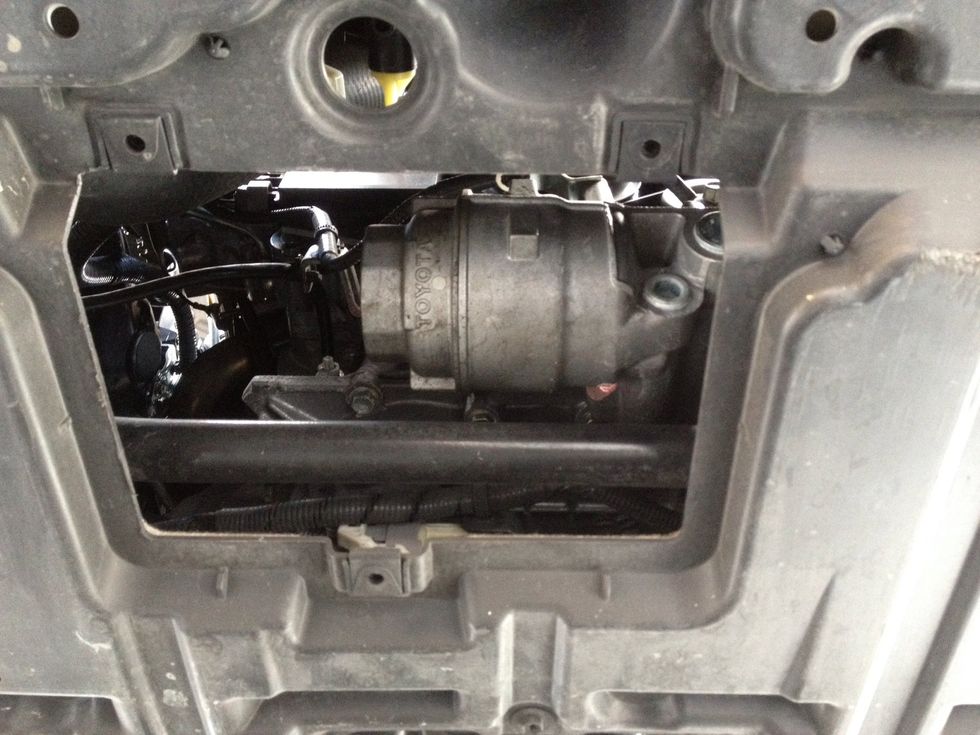 Directly in front of the drain plug, you will see a removable panel that will reveal the oil filter