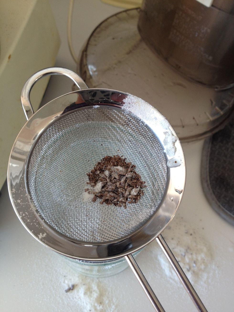 Discard chunks of vanilla bean pod left in sifter.
