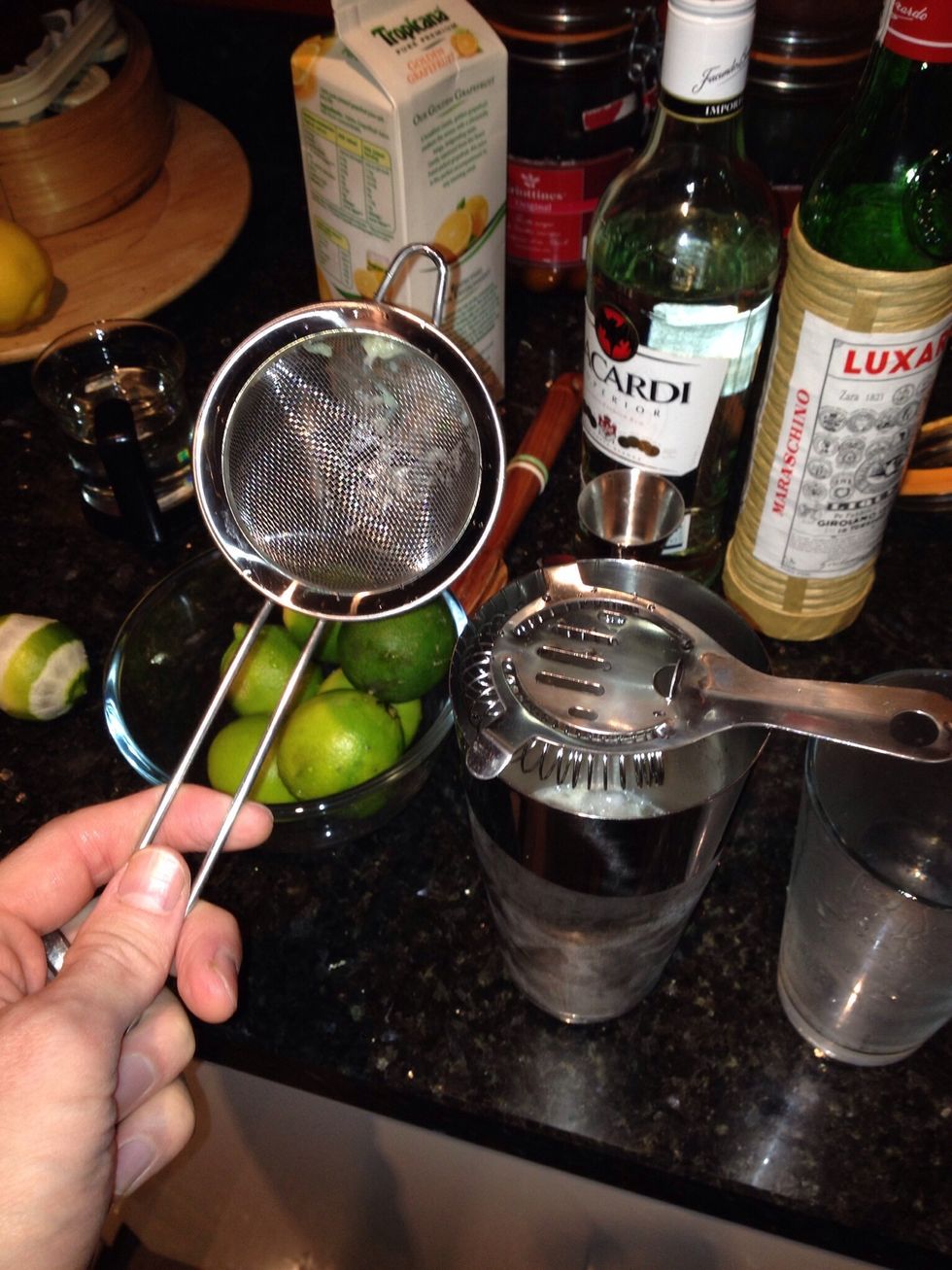 Discard the ice from the martini glass and double strain your concoction in using a Hawthorne strainer (the one with the spring) and the fine strainer.