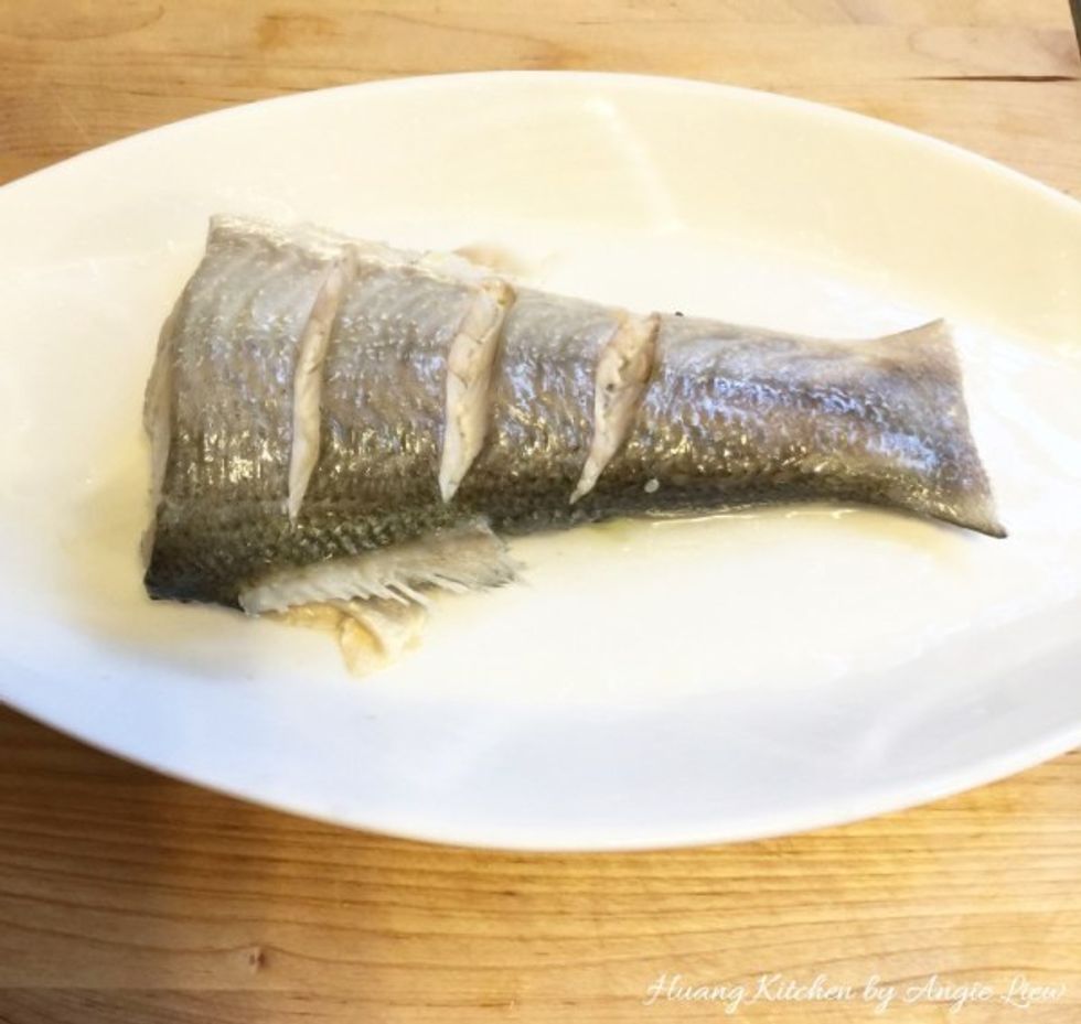 Discard the liquid and spring onions from the steamed fish.