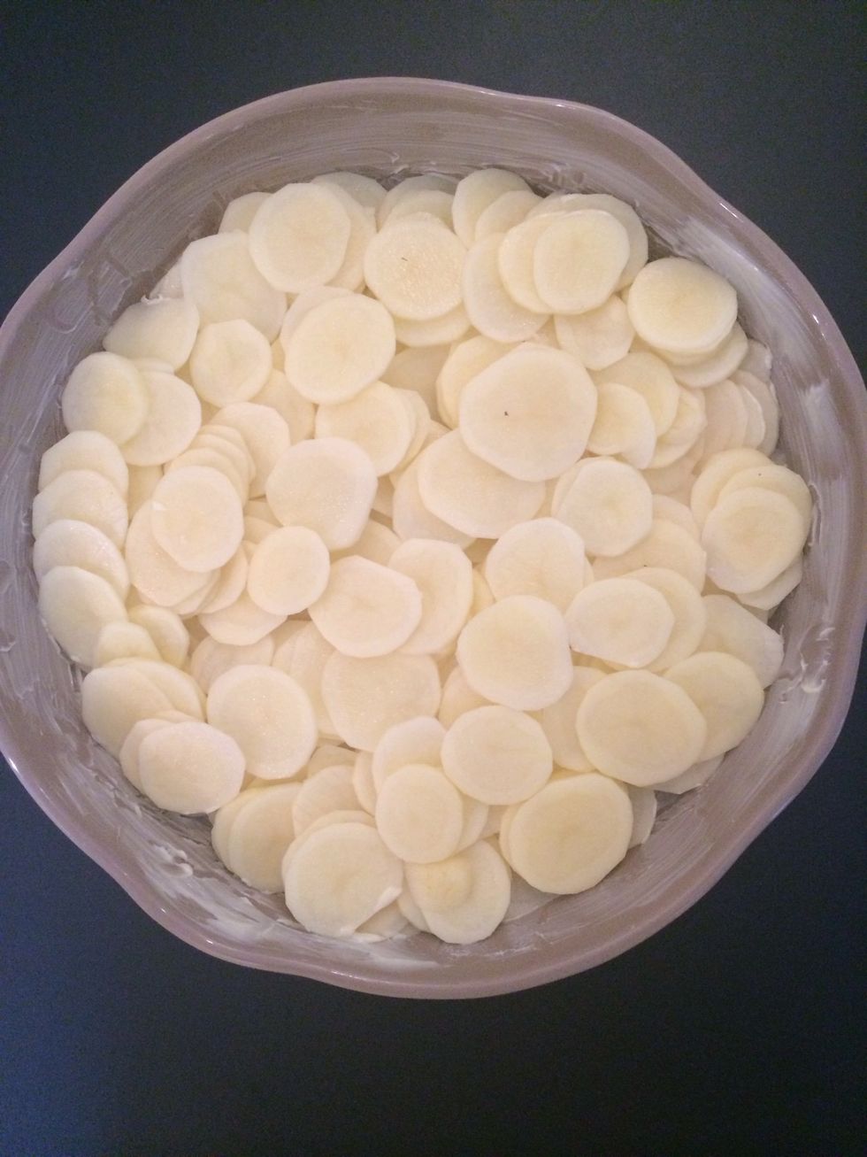 Dispose the potatoes in a dish ( 26-30 cm) that can go to the table and may b to the microwave. Layer the sliced the potatoes.