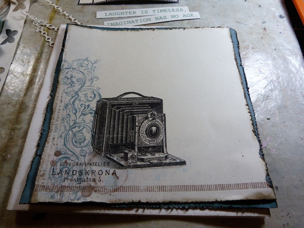 Distress and ink all the edges of the blue and camera papers with Distress Ink Frayed Burlap. Adhere the camera paper to the blue paper.