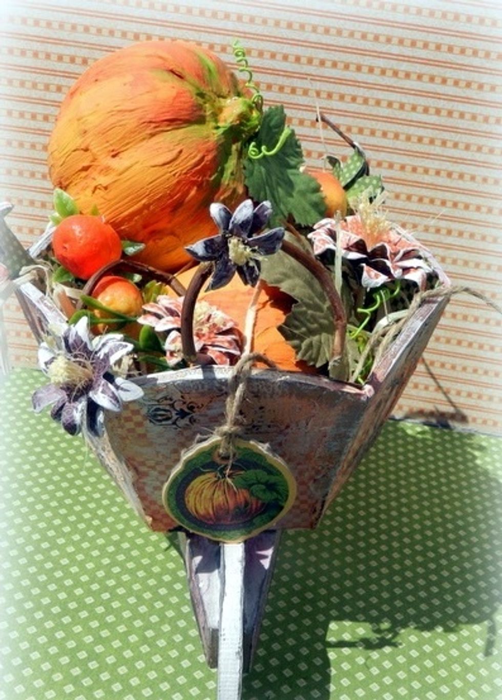 Distribute the pumpkins, flowers and branches inside the wheelbarrow and hang a tag G45 An Eerie Tale Decorative Chipboard.