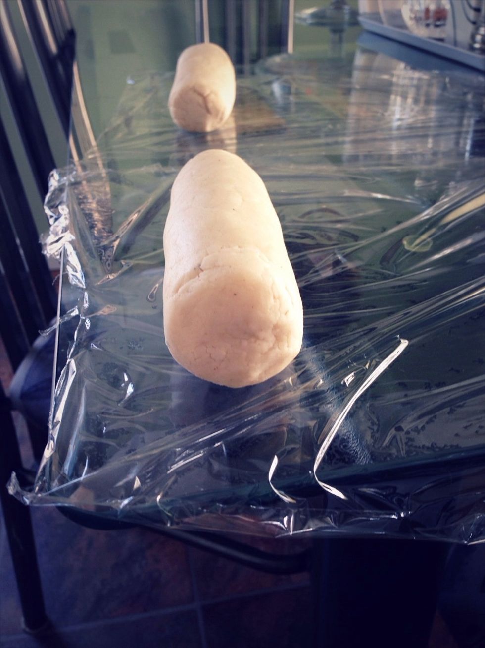 Divide the dough in half and shape it into two 6-inch long logs. Wrap each log in plastic wrap.