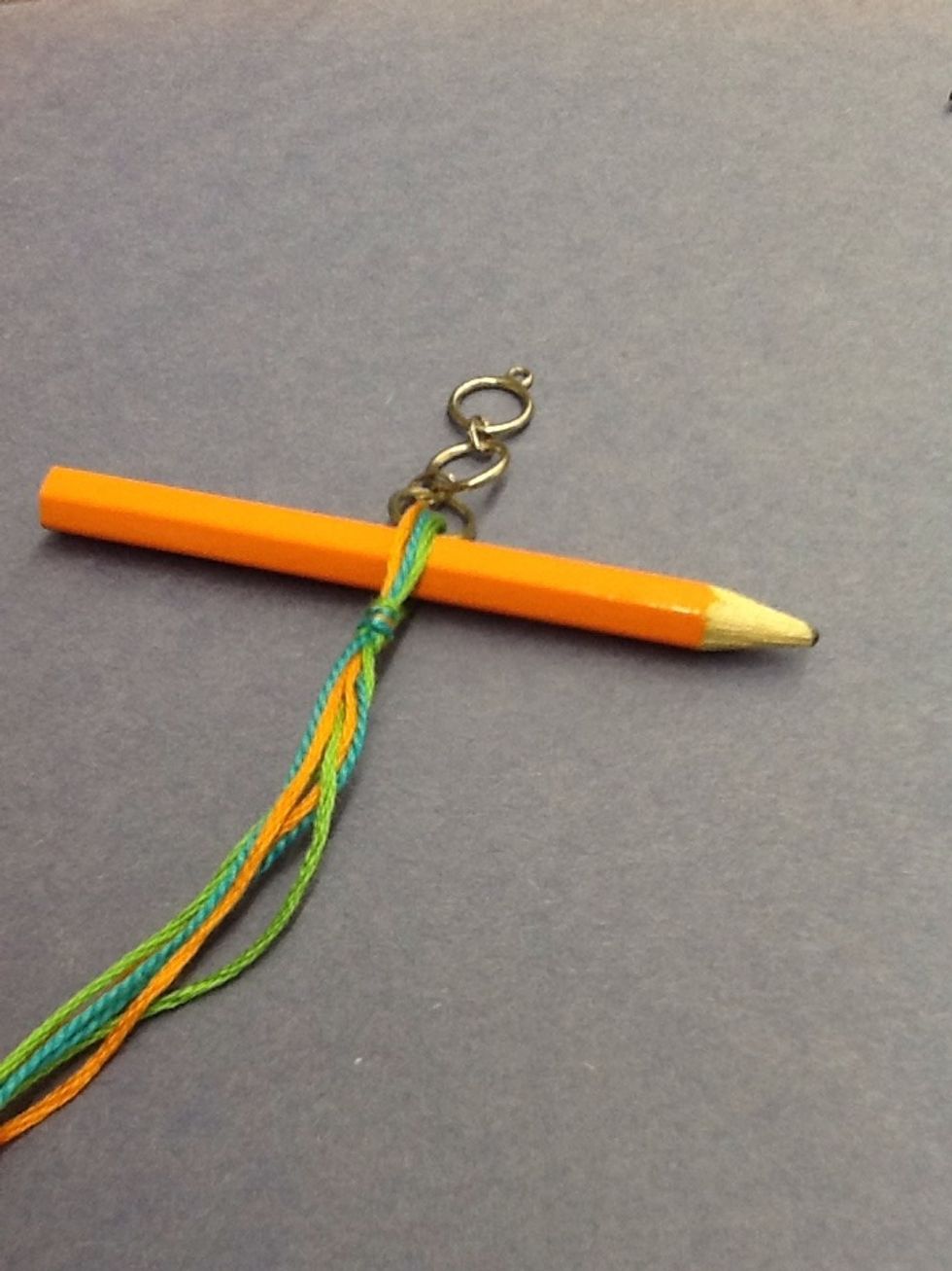Divide the threads evenly and put a pencil in the middle, then tie a knot.