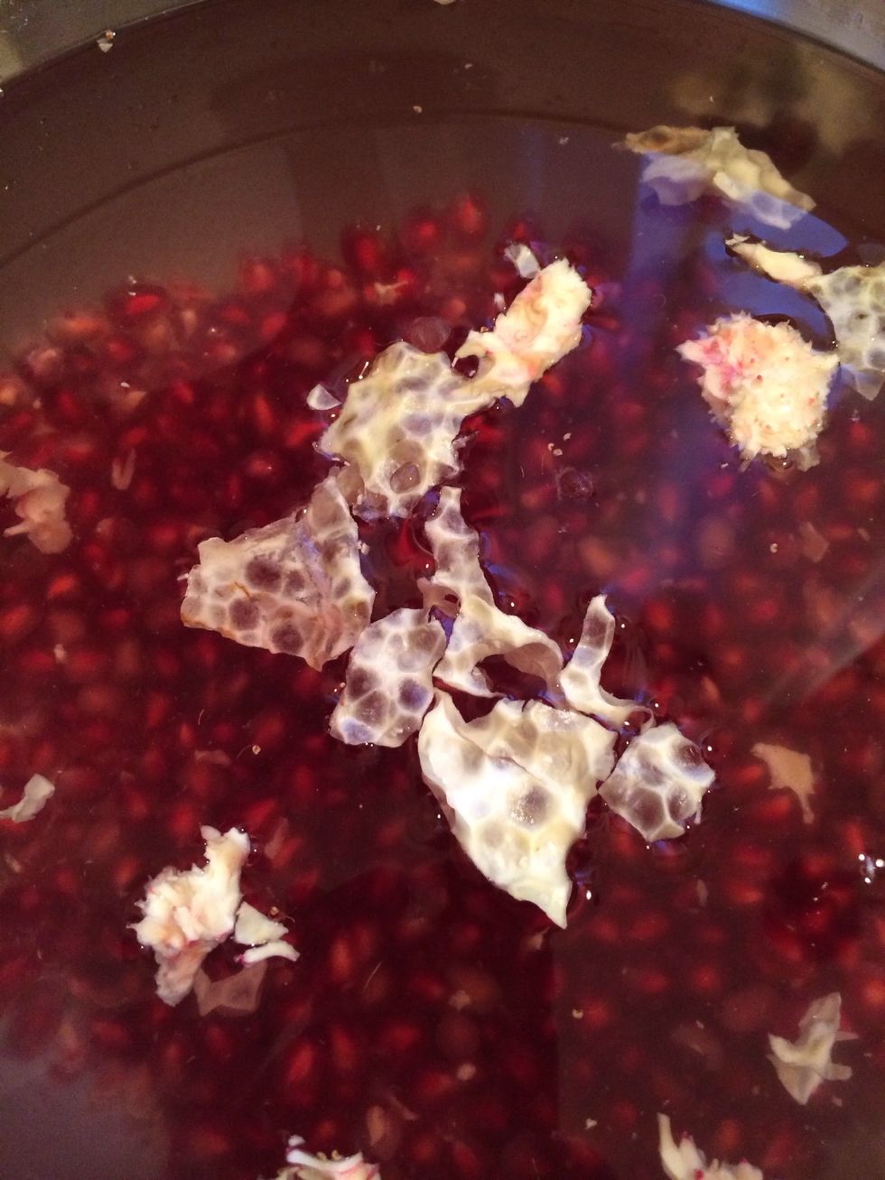 Do it for all quarters. Seeds now are at the bottom of the bowl, white stuff is floating on top. Remove the white peels, drain the seeds.