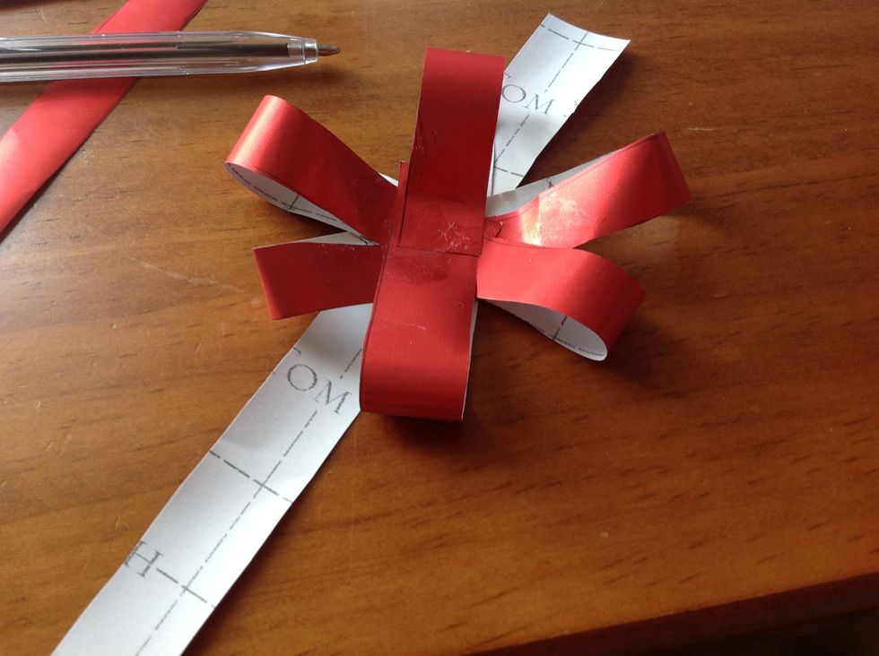 Do the same as the previous steps: add glue in the middle, then bring over the other strips.