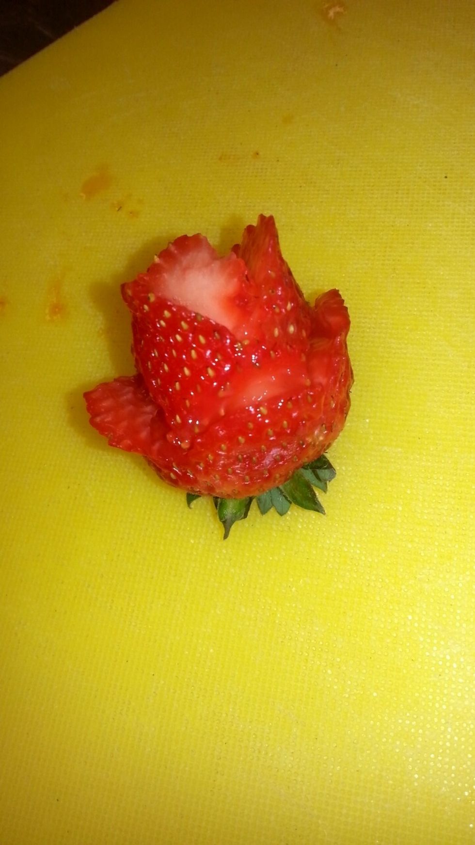 Do the same for the upper flaps fanning them out like a petal, after cut the tip of the strawberry and you're done!