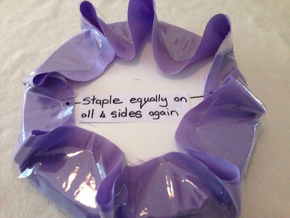 Do the same in the centre of the 4 sides, keeping material & plastic firmly together.