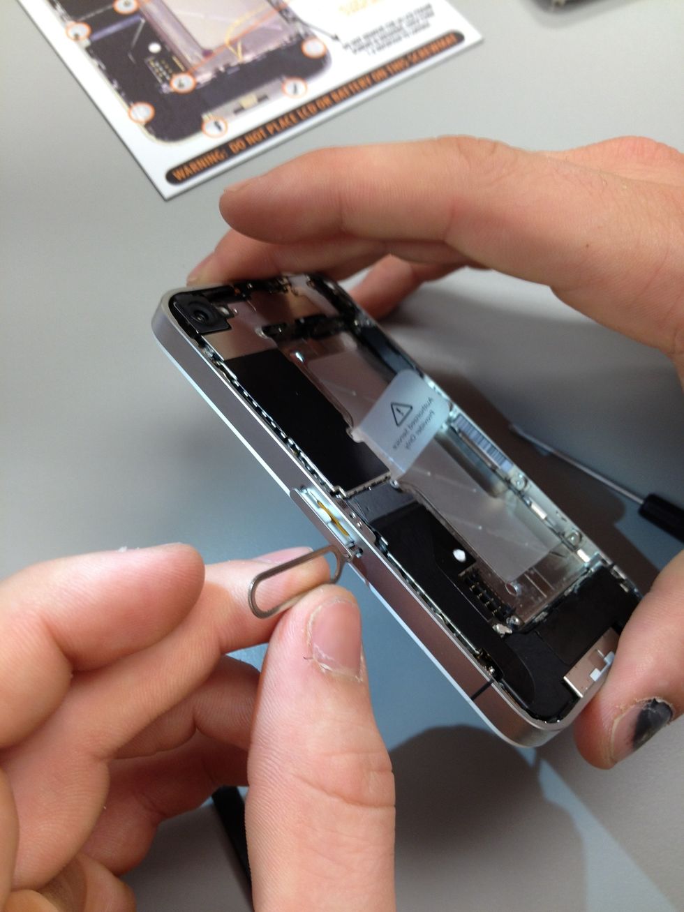 Do you know where your sim card eject tool is? It came with the original packaging. If not, a paperclip can be used in its place. Remove the sim card and it's holder.