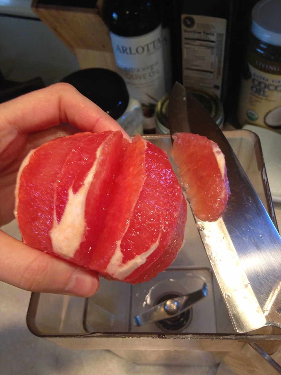 Doing this over the blender, or a bowl to catch the juice, slice between the membrane of the grapefruit to cut out the fruit, you can see the lines created by the pith. Continue all around the fruit.