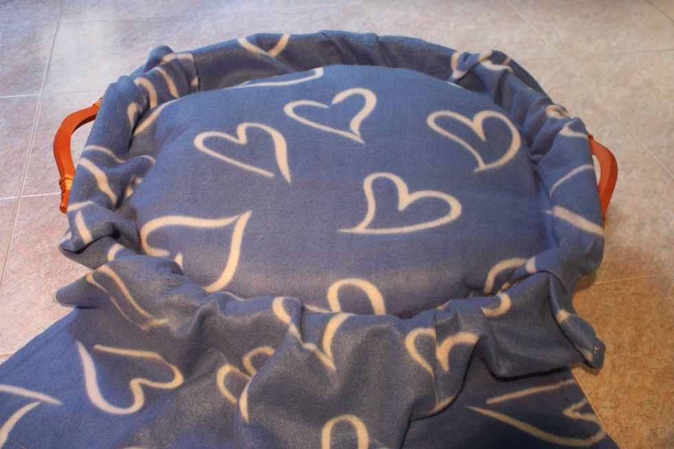 Dopo aver tagliato a met\u00e0 la coperta, stendine una parte sul cuscino e sistemala come nella foto.