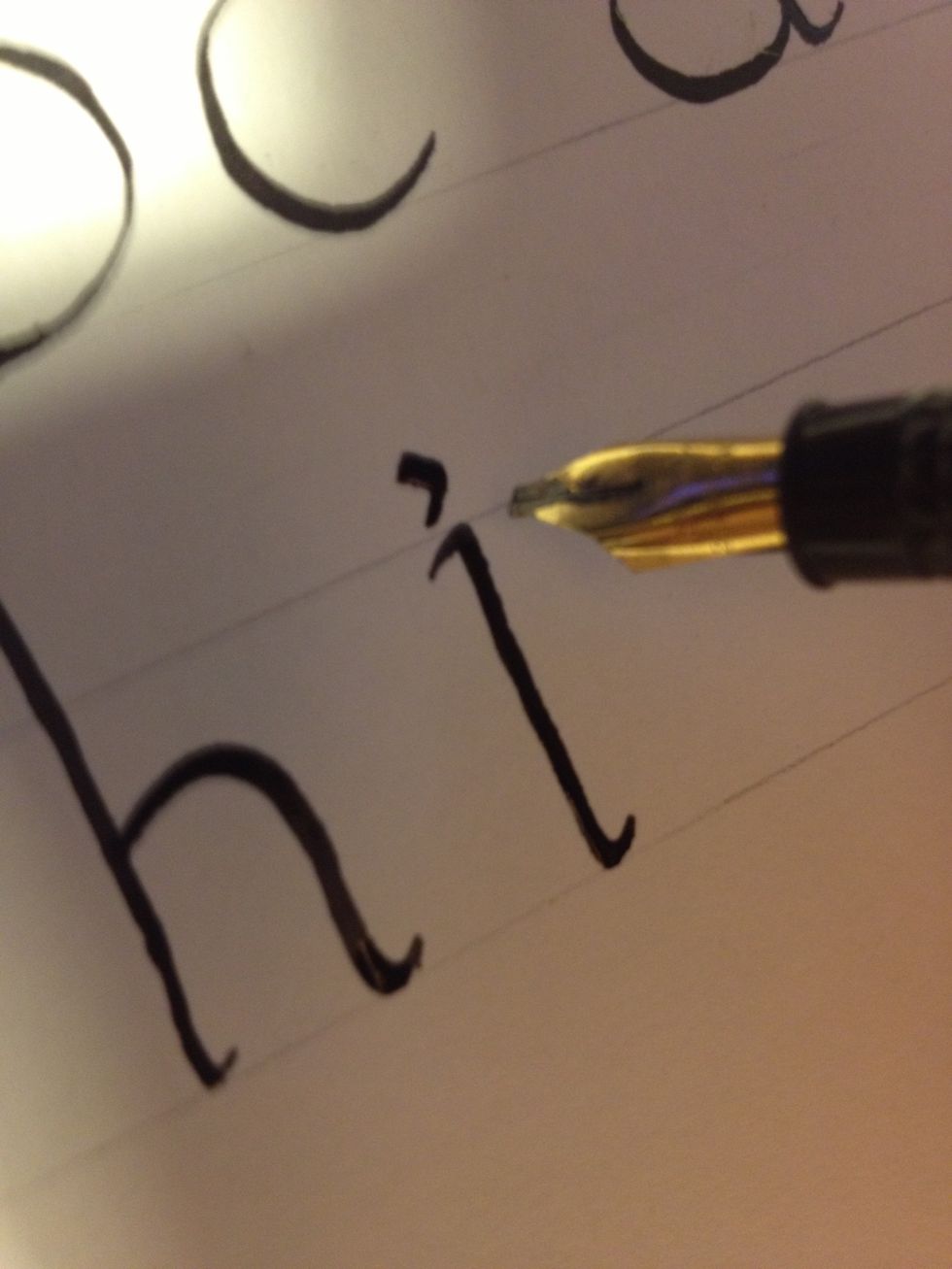 Dot the "i" by drawing a tiny half-circle clockwise. If you keep the same nib angle, it should look like a comma, as shown.