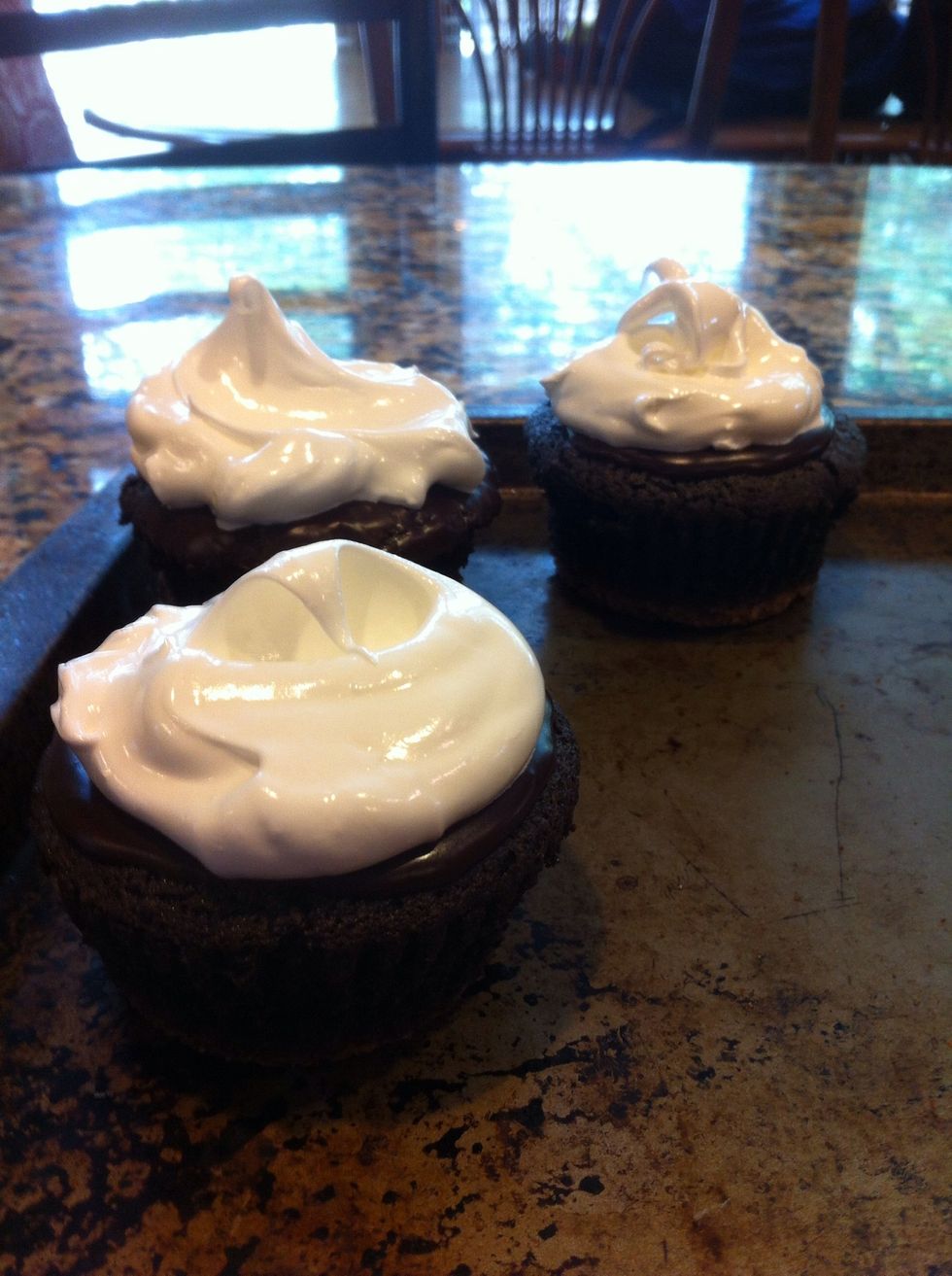 Double broiler: 4 egg whites and 1 c sugar. Let that warm for about 10 minutes. Then place in mixer and beat about 5-8 minutes. Shiny, stiff peaks. Dollop atop the cupcakes and place on cookie sheet