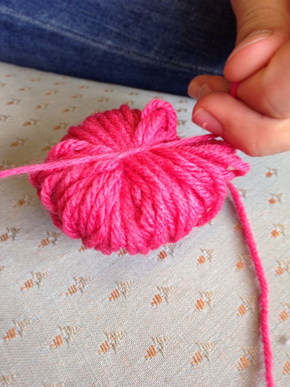 Double knot the five inch piece of yarn around the roll