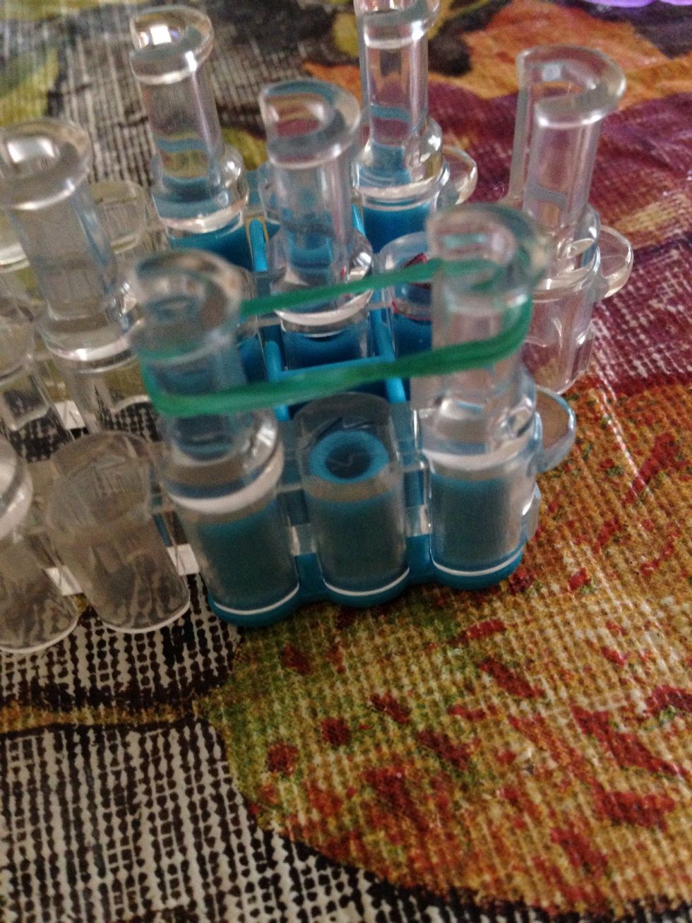 Double your green rubber band and place it on this peg