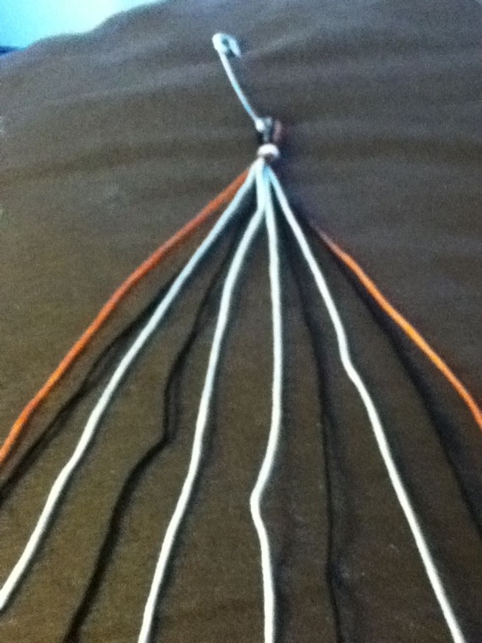 Double your threads, tie off leaving a loop, safety pin it to the work surface and separate your threads.