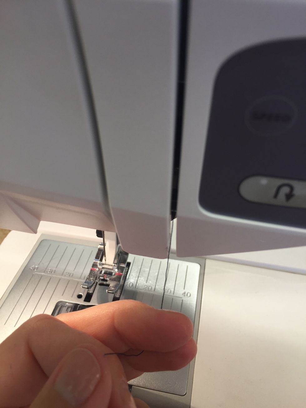 Dra tr\u00e5den ner mellan metallbrickorna.