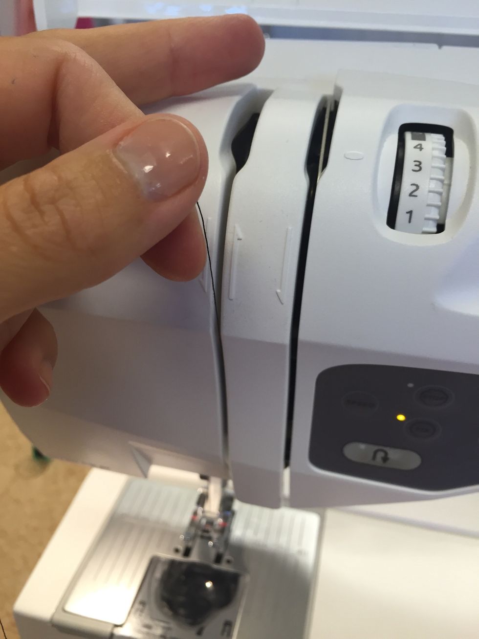 Dra tr\u00e5den upp\u00e5t igen, f\u00f6lj pilarna som syns p\u00e5 maskinen. De visar hur tr\u00e5den skall g\u00e5.