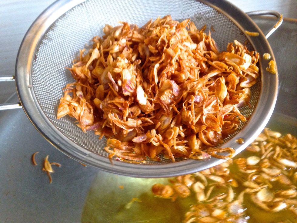 Drain the crispy shallots from the oil into a sieve.