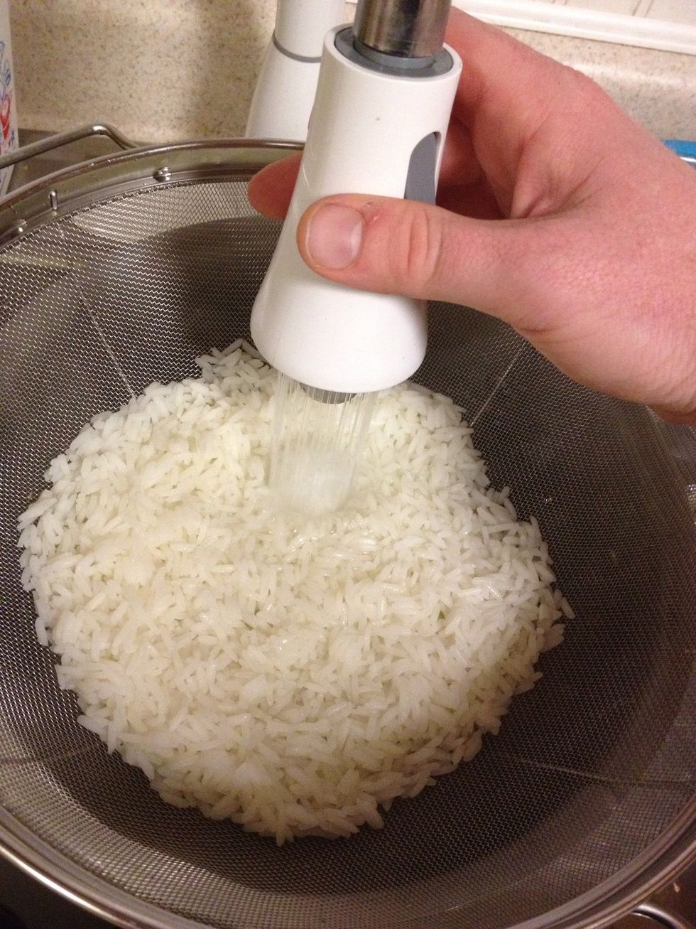 Drain the rice into a metal colander, the. Put the colander back on the pot and rinse the rice a little bit. Leave about an inch of water in the pot and put it back to boil. Cover the rice with foil.
