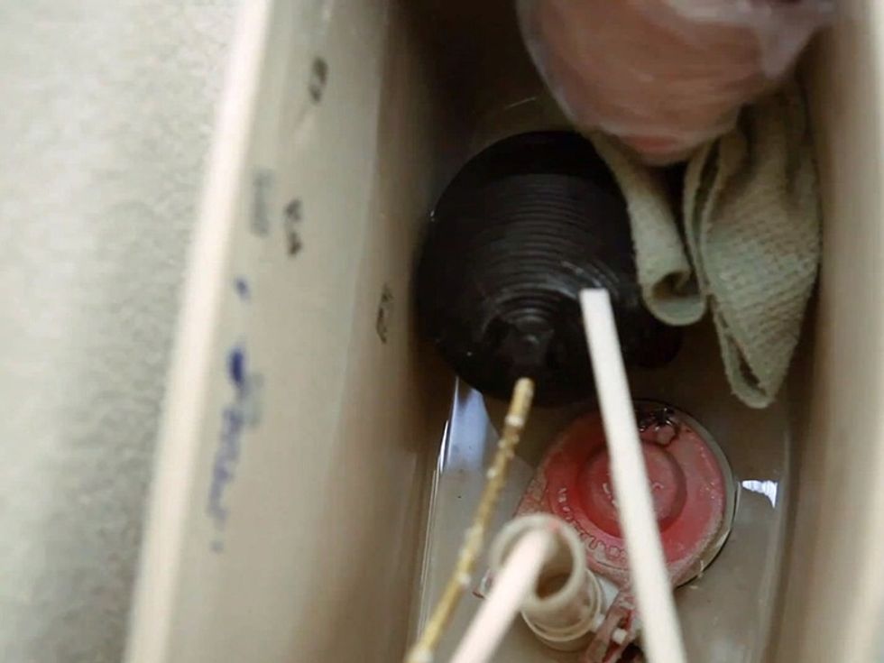 Drain the toilet with one last flush. Then with a rag or towel, soak up the tank's remaining water. If necessary, push any remaining water in the bowl down with a plunger.