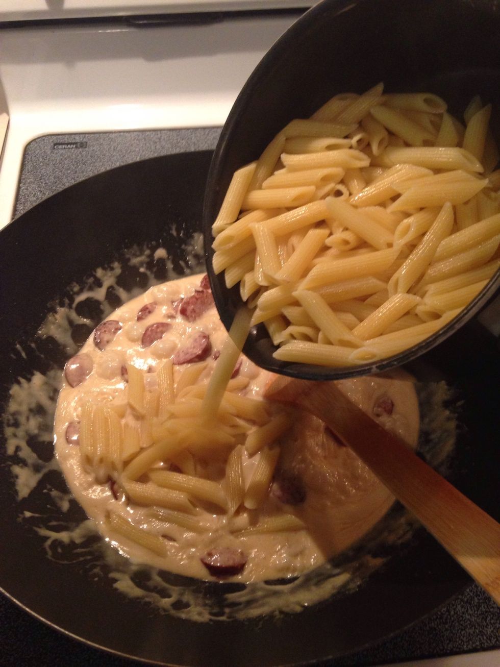 Drain water from pasta and add pasta to mixture. Stir well.