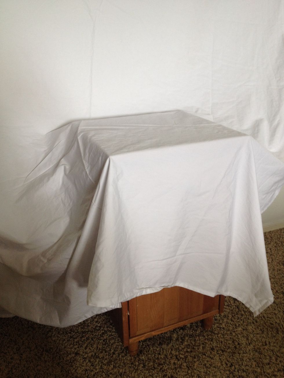 drape the sheet over a side table