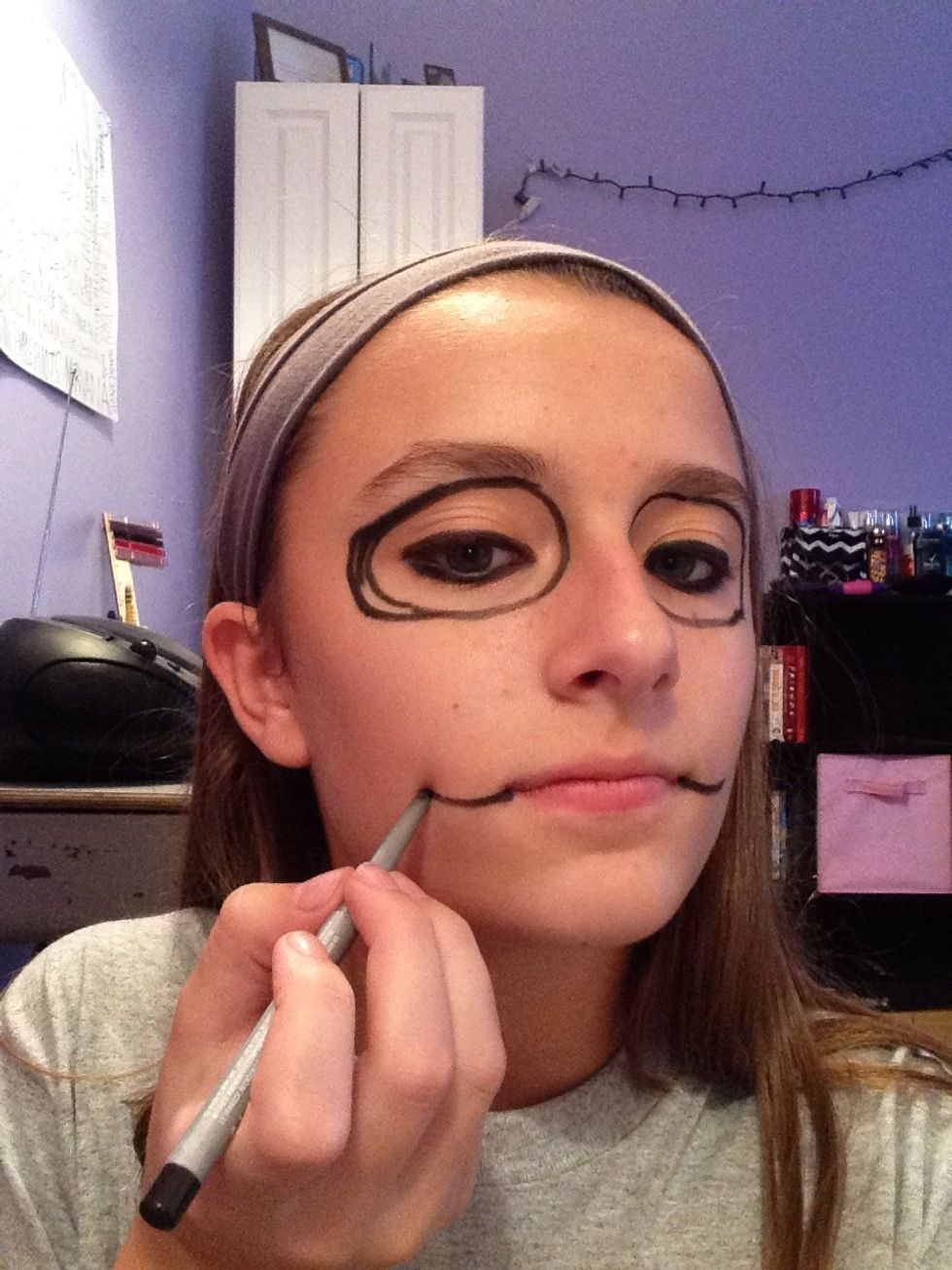 Draw 2 lines coming out of your lips with black eyeliner, to create the stitches