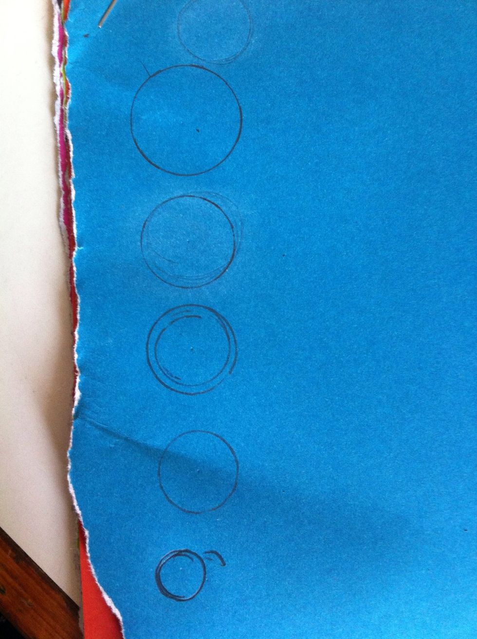 Draw 5 circles in a descending order of size on a colored sheet of paper from any magazine/newspaper/brochure etc.