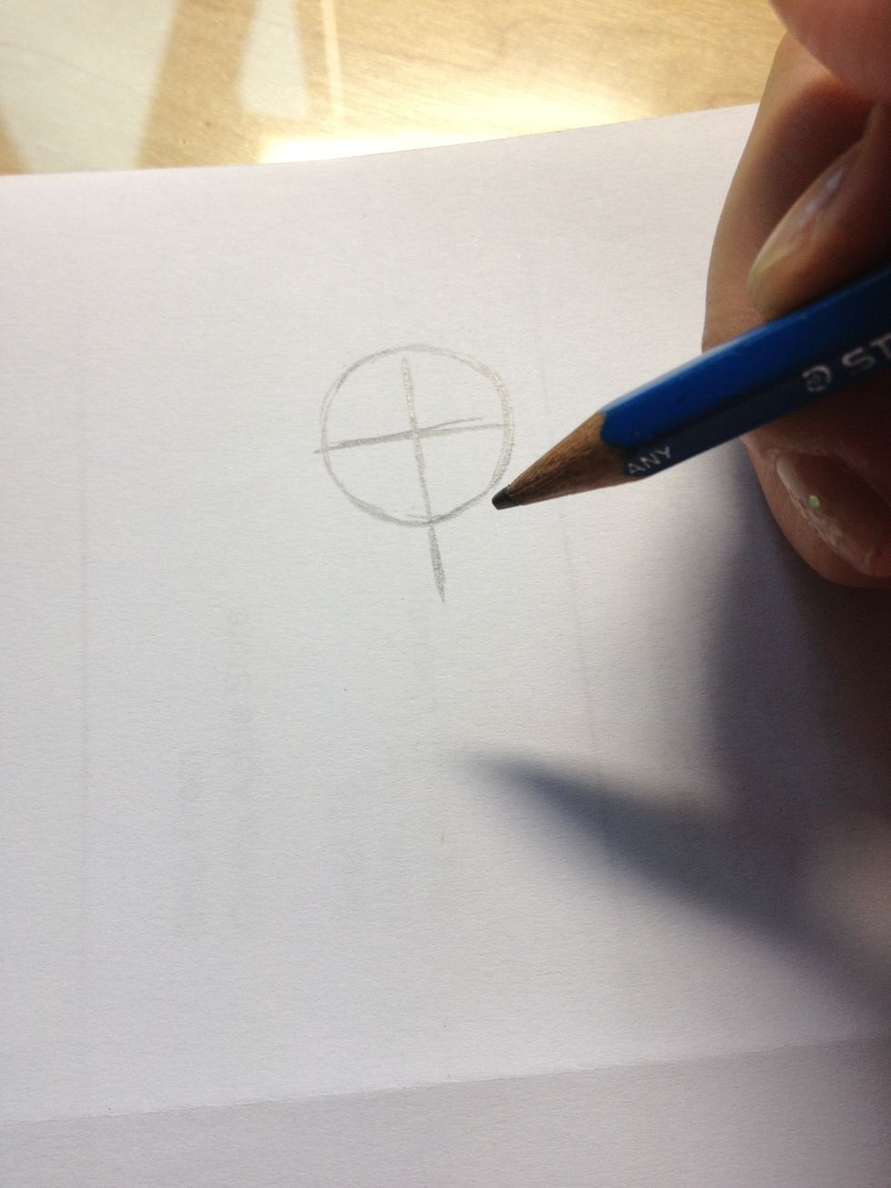 Draw a cross inside the circle and the vertical one should be longer than the diameter of the circle a bit
