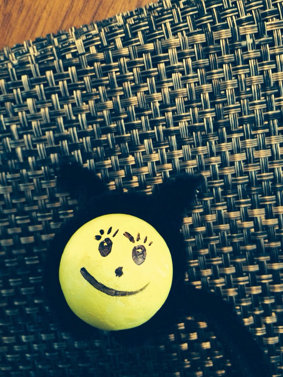 Draw a face onto the bee using your black marker.