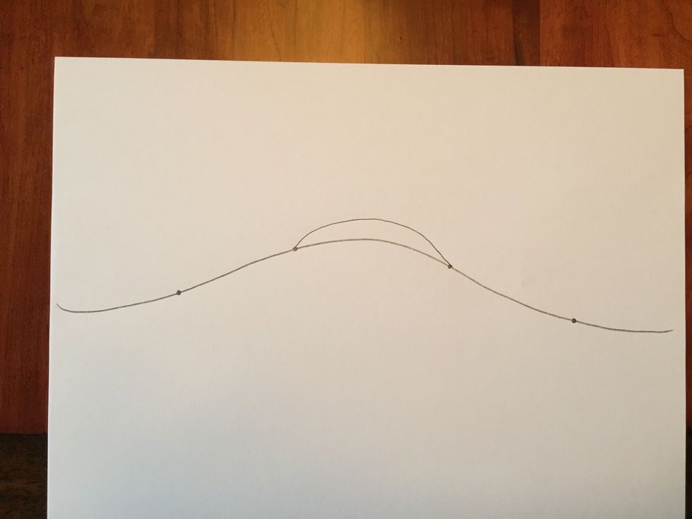 Draw a upward curved line connecting two of your dots. It doesn't matter which two you start with as long as they are next to each other.
