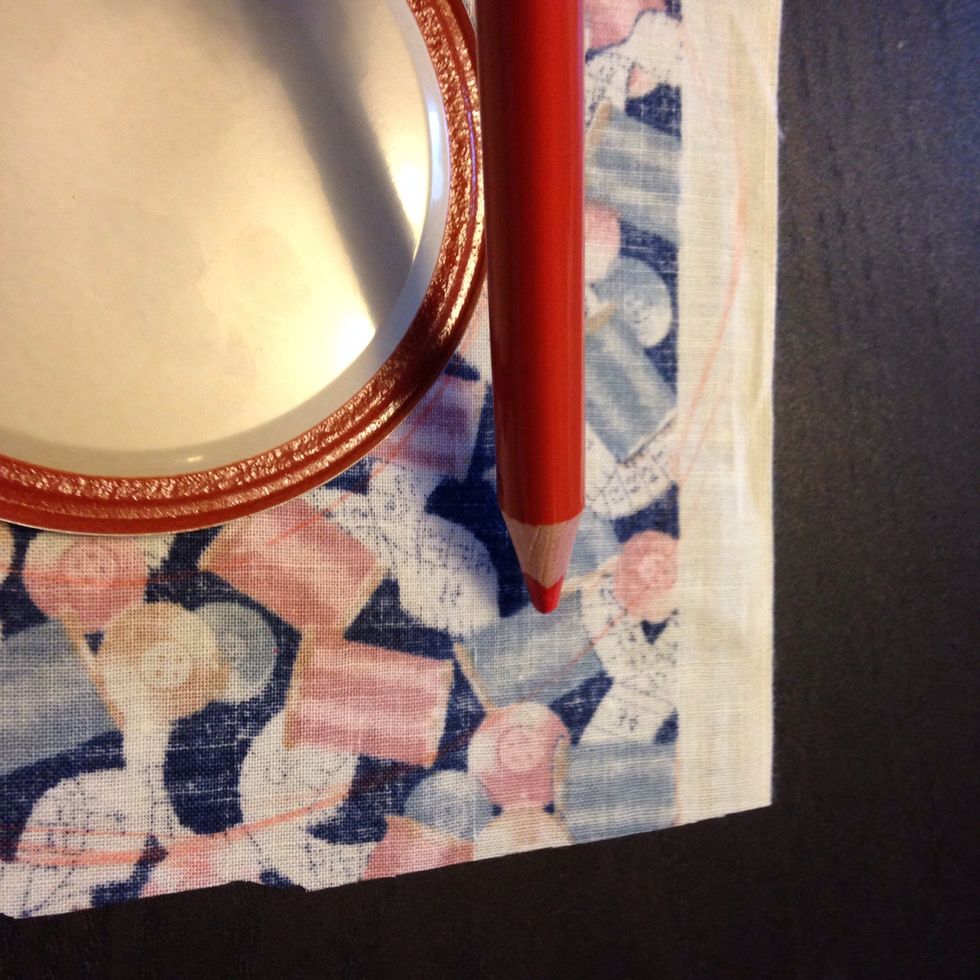 Draw another circle one inch outside the edge of the lid and then cut out that circle.