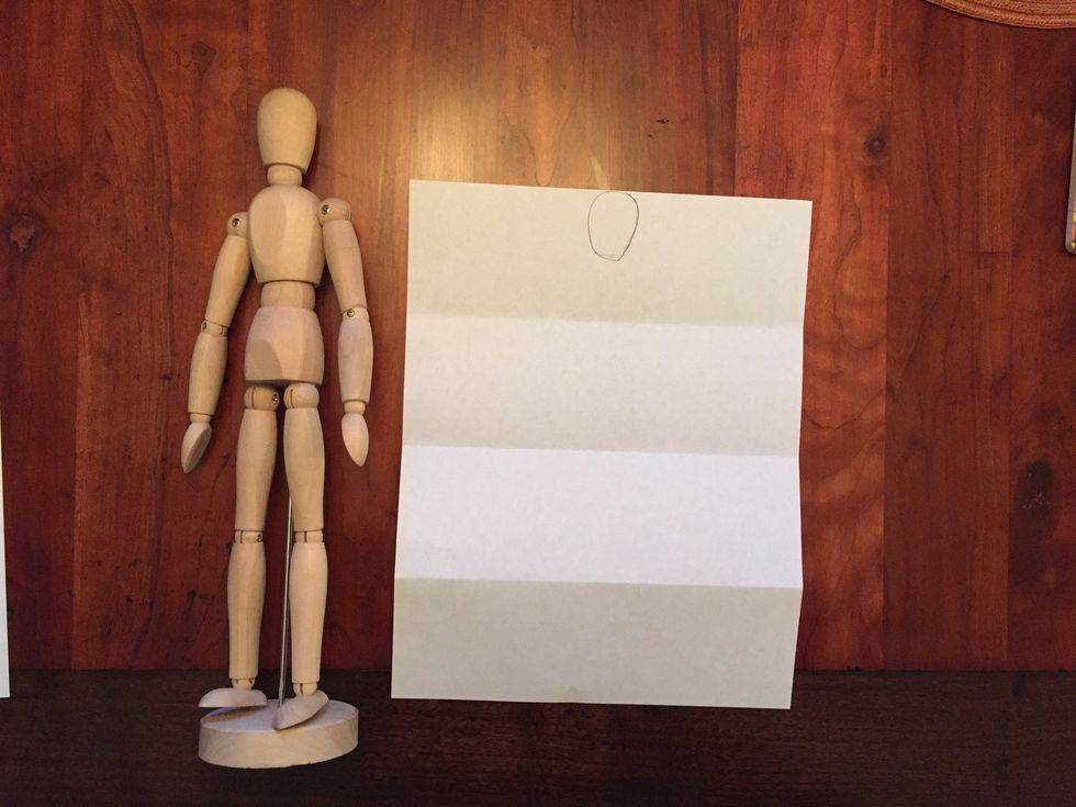 Draw Bob's head. His head should touch the top of your paper and come half way down into your first folded section.