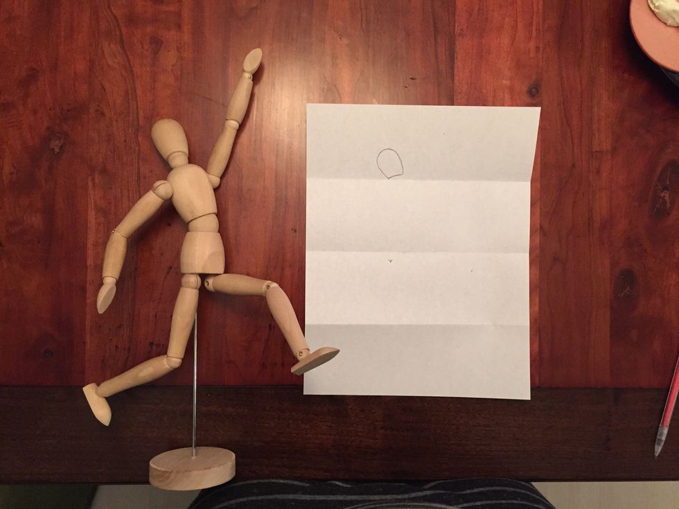 Draw Bob's head. The bottom of Bob's head should almost touch your first fold. Bob's head should fill half of your top section above the fold. Notice how Bob's head is tilted a little.