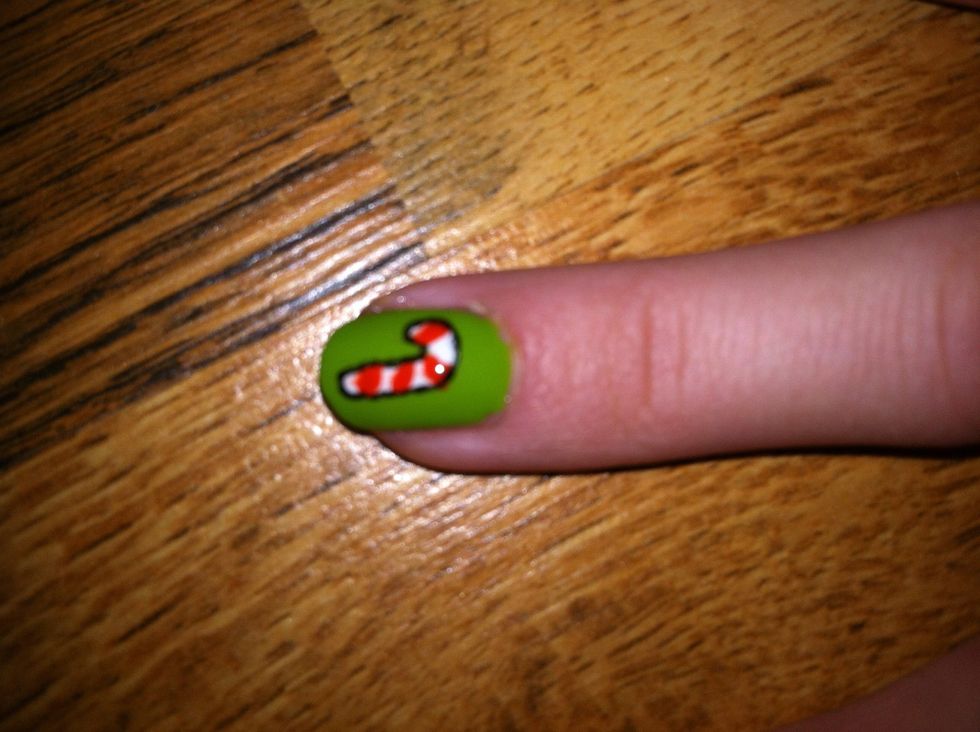 Draw diagonal stripes on your candy cane shape with red nail polish. I also outlined this one with black nail art pen. You can use a toothpick or a pencil for that if you don't have a nail art pen