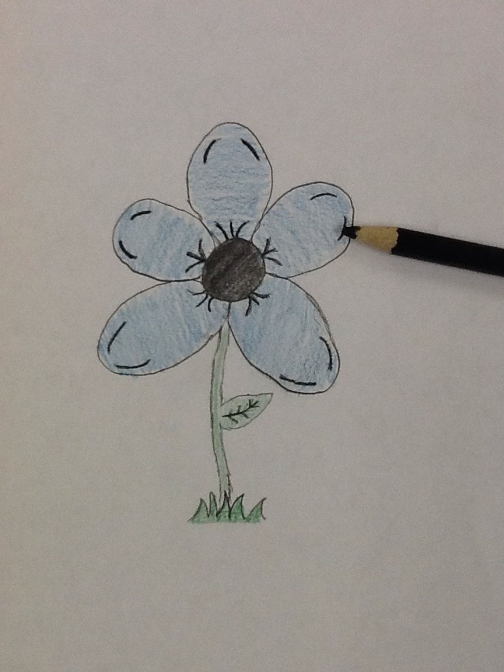 Draw over the lines in your petals with a black colored pencil make sure to include the circle in the middle and the veins on the leaf.