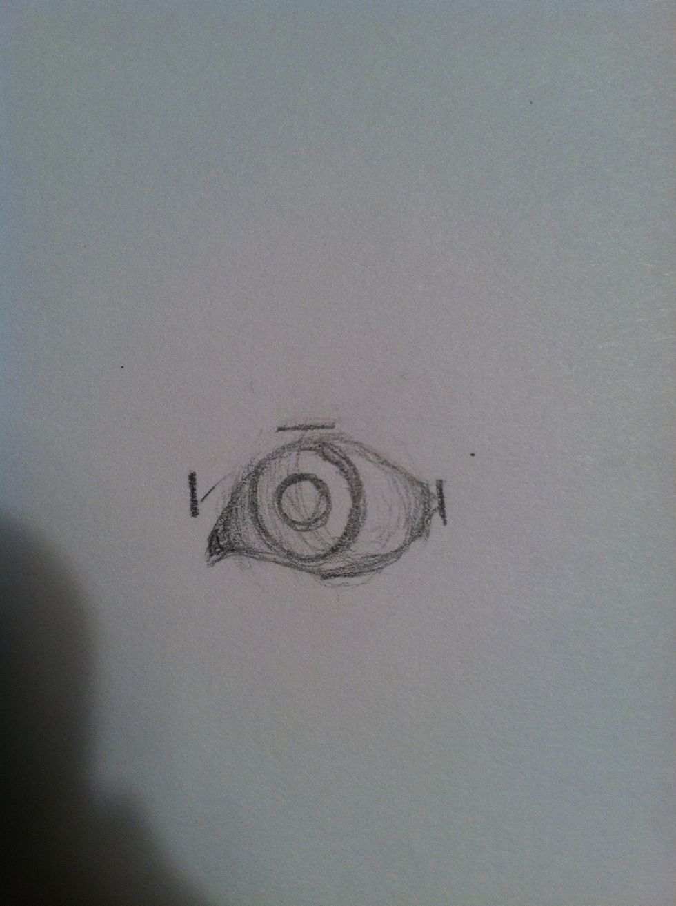 Draw the pupil at the center of the eye. Now we'll begin shading.