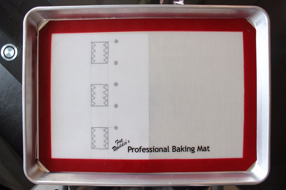 Draw your Domo-kun design with a permanent black marker on a sheet of plain white printing paper. Place your template under the silicon mat like so (not too high and not too low).