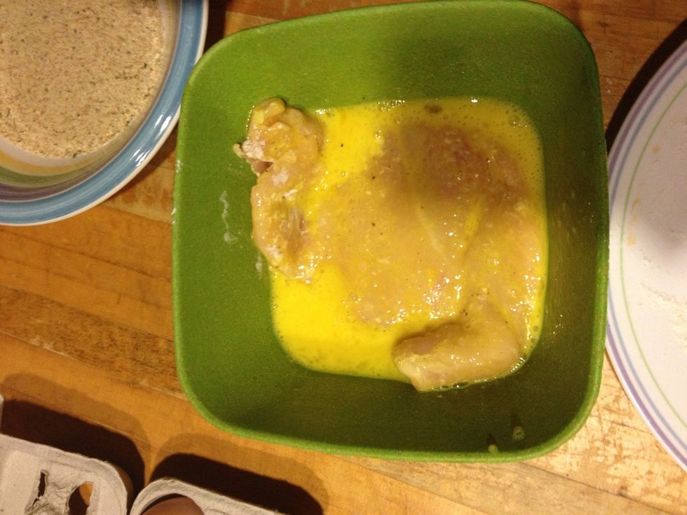 Dredge the chicken in the egg so that breadcrumbs will stick to it