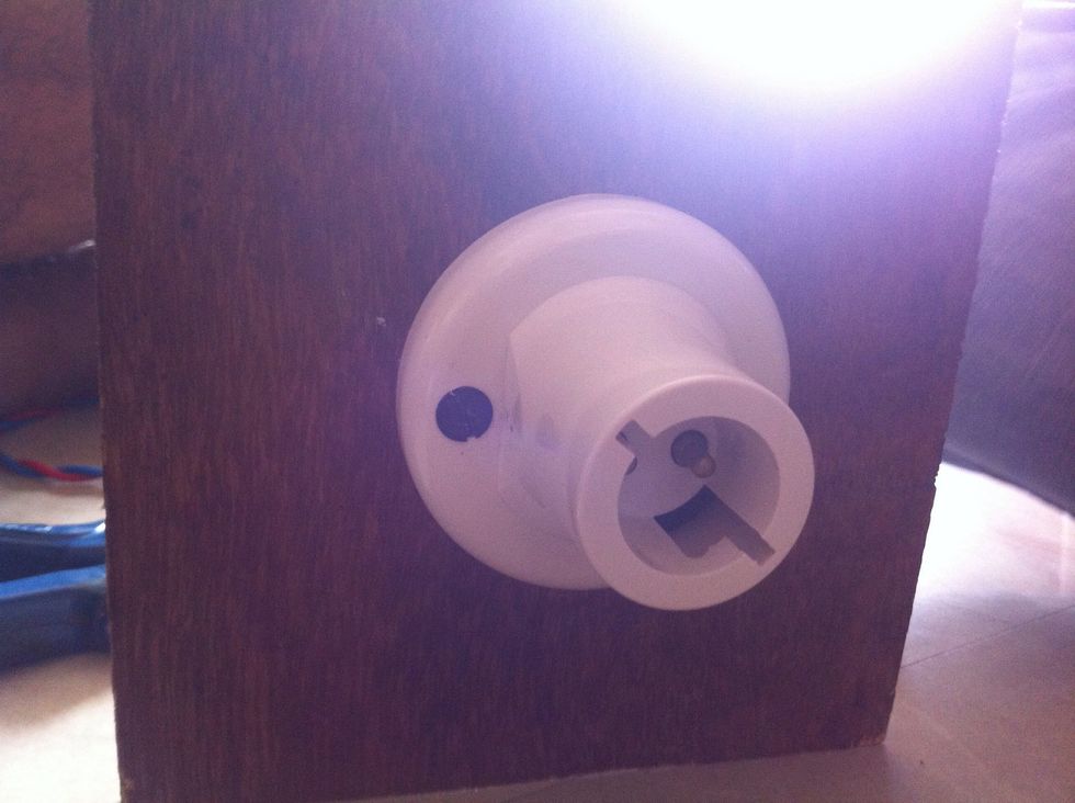 Drill into centre of one square which we have already cut. Pass the wires from the hole and fix them with bulb holder. And then fix the bulb holder to plywood with screws.