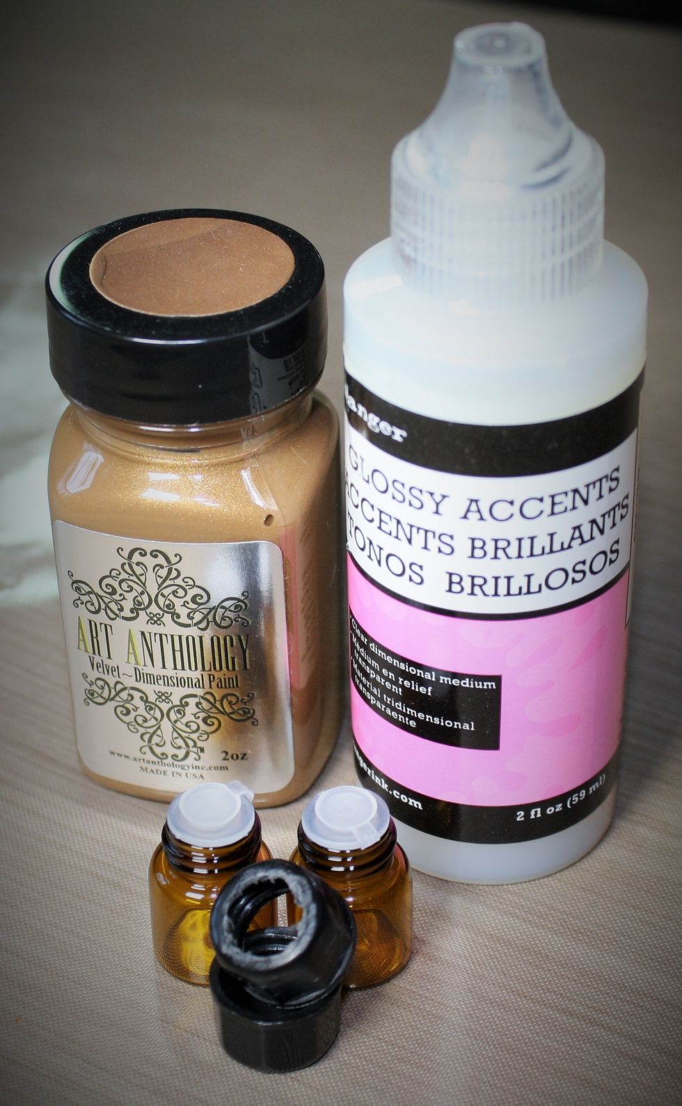 Drill out the top of the bottle caps, sand down the cap to remove any stray parts, then paint with Art Anthology Kona, once that is dry, flip caps over top down and fill with Glossy Accents