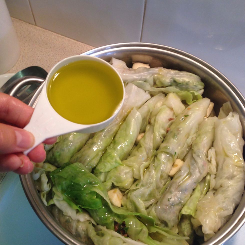Drizzle a quarter cup of olive oil over the rolled cabbage.