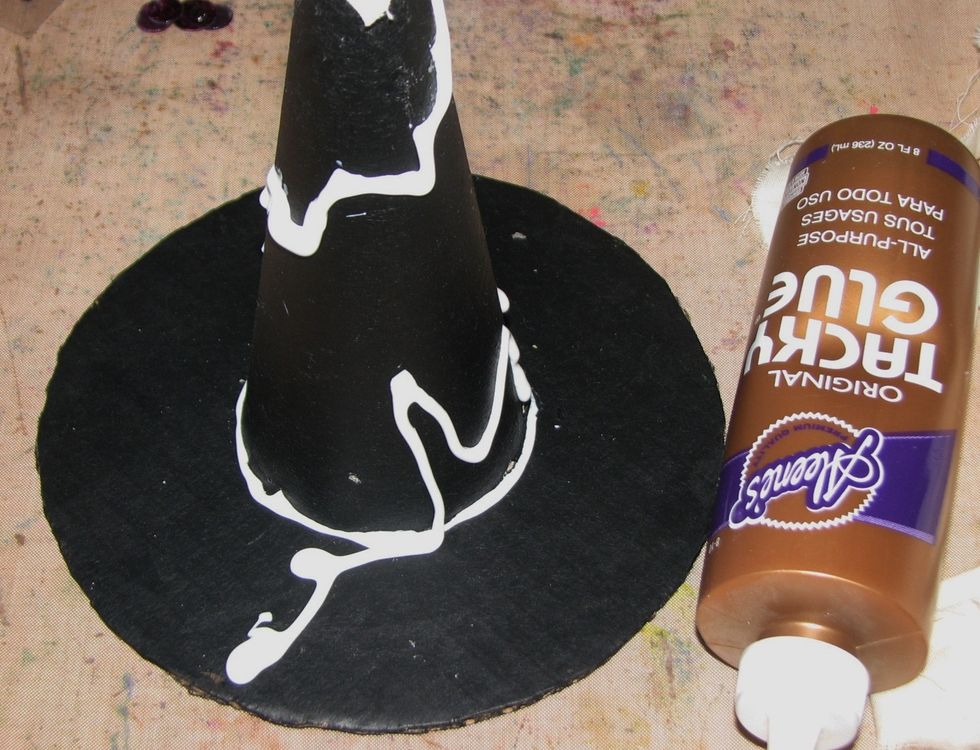 Drizzle glue around the hat in a spiral design and wrap the strips of muslin around the body of the hat.