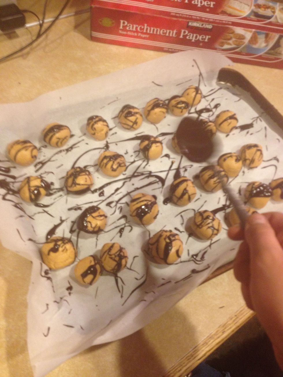 Drizzle over your peanut butter balls with a flicking motion