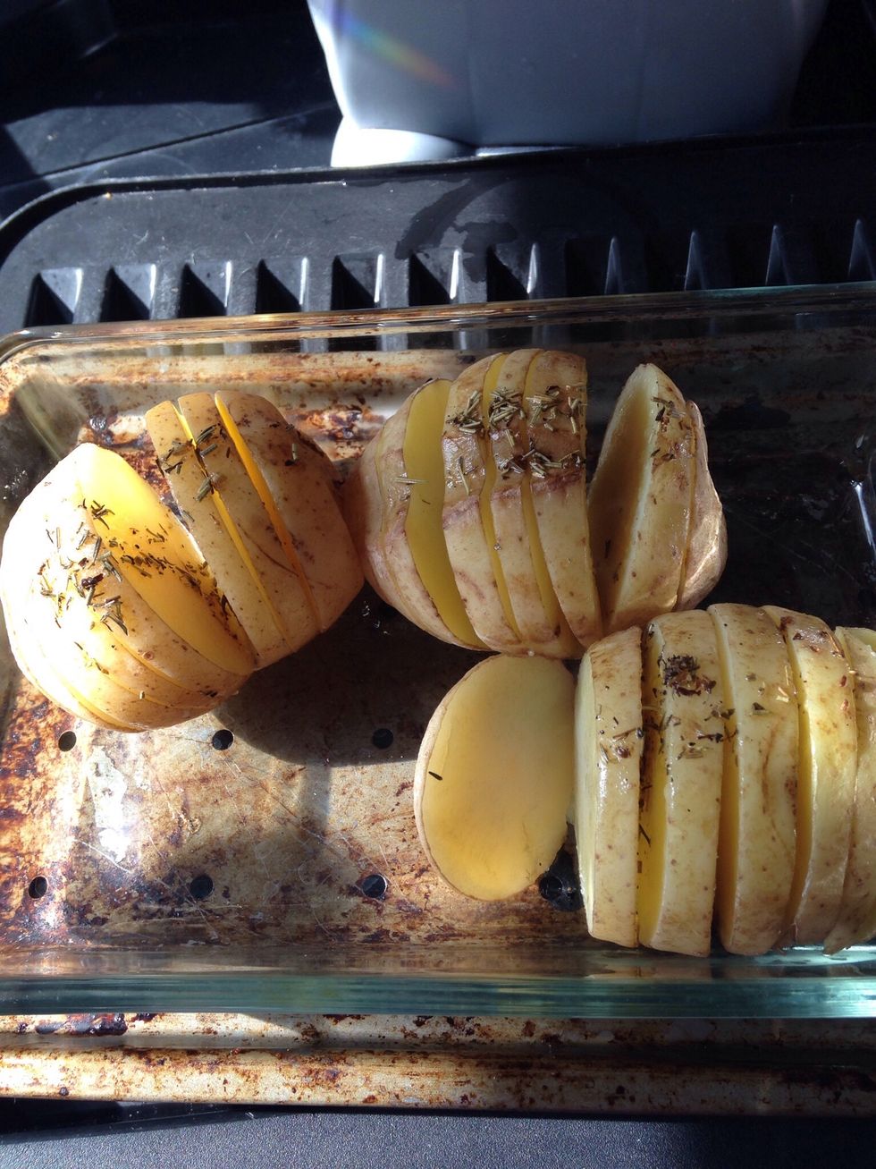 Drizzle the oil and herb mix over the potatoes  which  should be sliced.. but not right through  reserve some to use 1/2 way through the cooking. Put into the oven and cook for 45 mins at 200 degrees